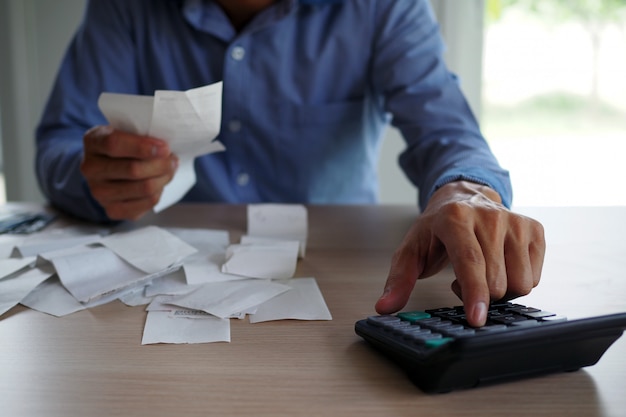 Les hommes d’affaires utilisent la calculatrice pour calculer la facture placée sur la table. concept de dette Photo Premium