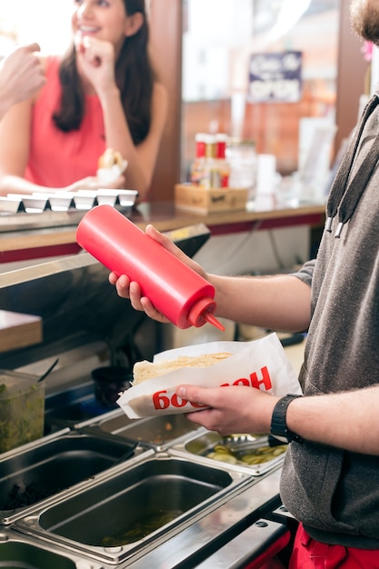 Hotdog  Vendeur Sympathique Et Ingrédients Frais Dans Un Snackbar De