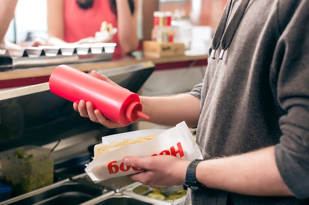 Hotdog  Vendeur Sympathique Et Ingrédients Frais Dans Un Snackbar De