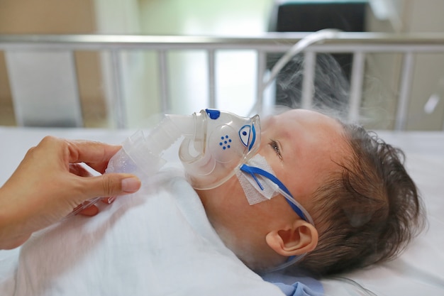 Inhalation bébé âgé d'environ 1 ans sur le lit du patient. virus respiratoire syncytial (vrs) Photo Premium
