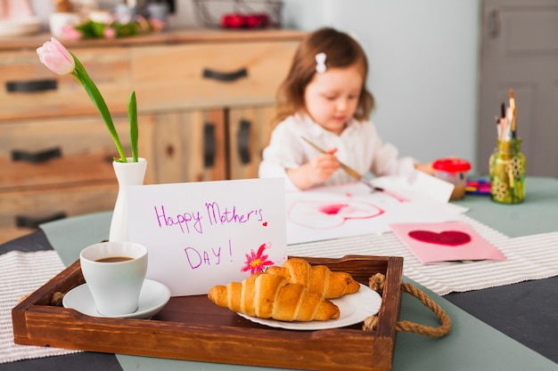 Inscription heureuse fête des mères sur la table près de coeur de peinture fille Photo gratuit