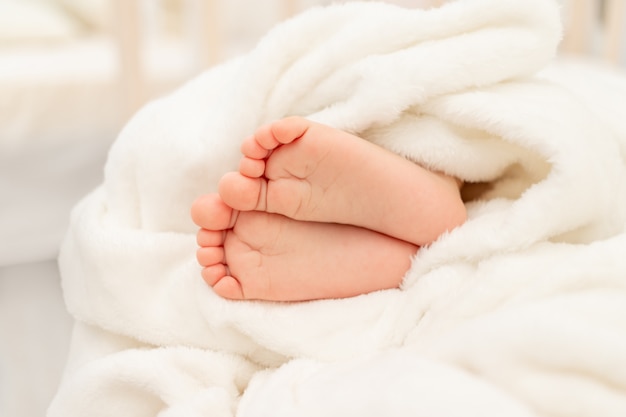 Les Jambes De Bebe Dans Un Lit Blanc Un Sommeil Sain Et Calme Pour Le Bebe Photo Premium