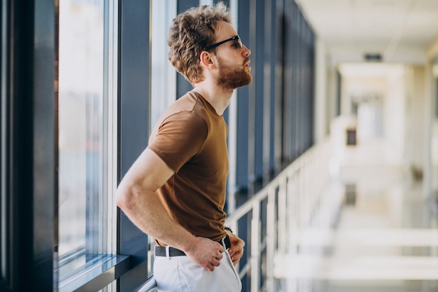Jeune Bel Homme Debout Près De La Fenêtre à L'aéroport Photo gratuit
