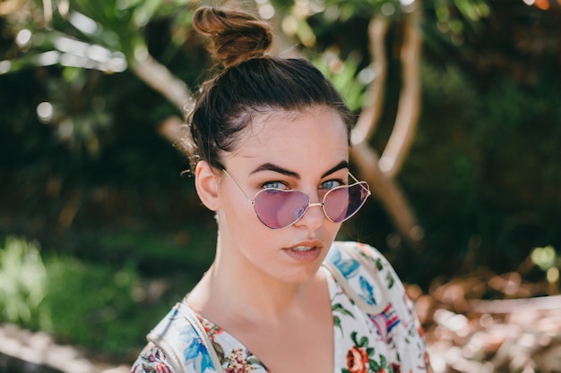 Jeune belle fille posant dans la rue dans une robe avec un sac à dos Photo gratuit