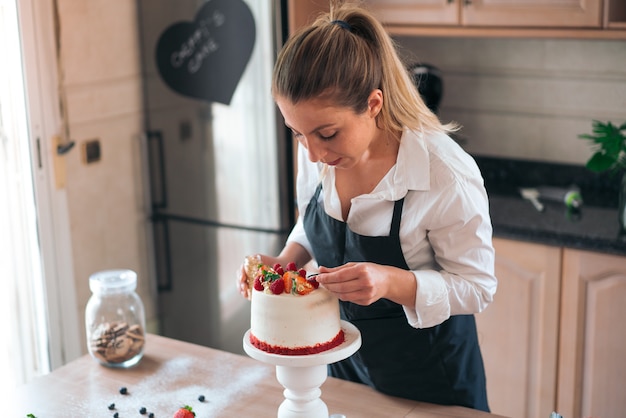 Jeune Chef Patissier Cuisinant Un Gateau De Velours Rouge Traditionnel Dans La Cuisine Photo Premium