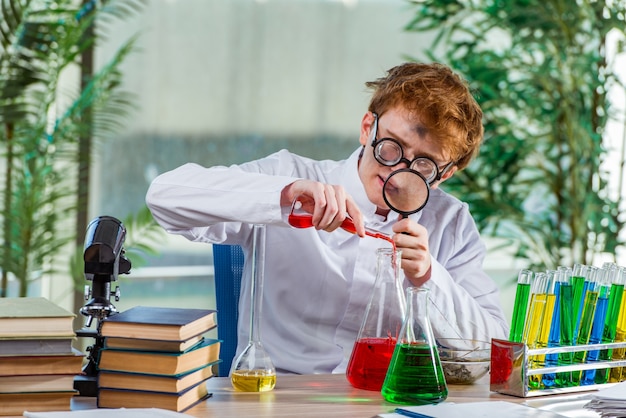 Jeune chimiste fou travaillant dans le laboratoire Photo Premium