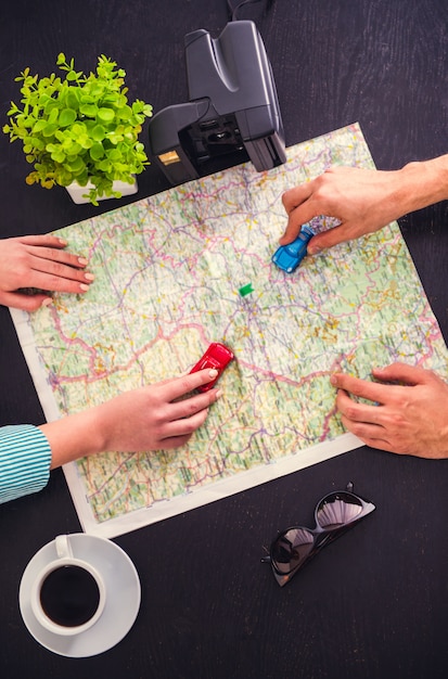 Jeune couple choisit un endroit pour voyager en utilisant la carte. Photo Premium
