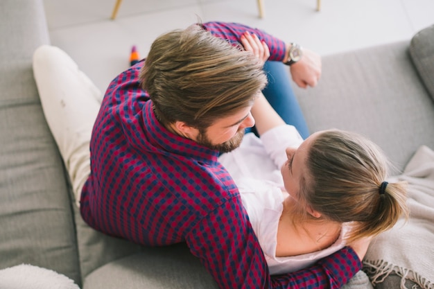 Jeune Couple Embrassant Sur Le Canapé Photo Gratuite 