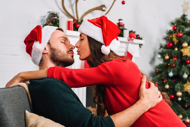 Jeune Couple Sembrassant Sur Le Canapé Photo Gratuite 