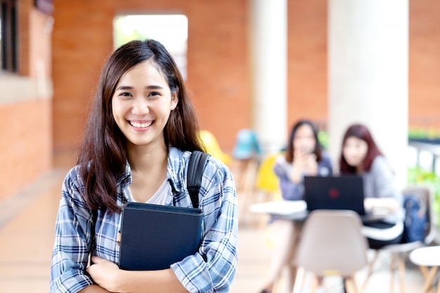 Jeune étudiant asiatique attrayant heureux souriant à la caméra Photo Premium
