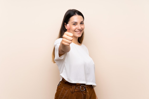 Jeune femme brune avec le pouce levé parce qu'il s'est passé quelque chose de bien Photo Premium