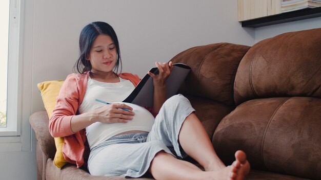 Jeune Femme Enceinte Asiatique Dessin Bebe Dans Le Ventre Dans Le Cahier Maman Se Sentant Heureuse