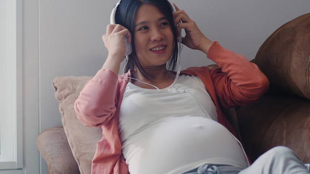 Jeune Femme Enceinte Asiatique Utilisant Un Telephone Et Un Casque Joue De La Musique Pour Bebe