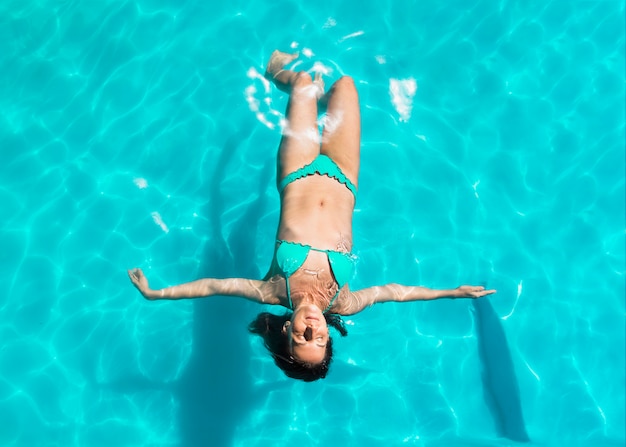 Jeune Femme Flottant Sur Le Dos Dans La Piscine Photo Gratuite