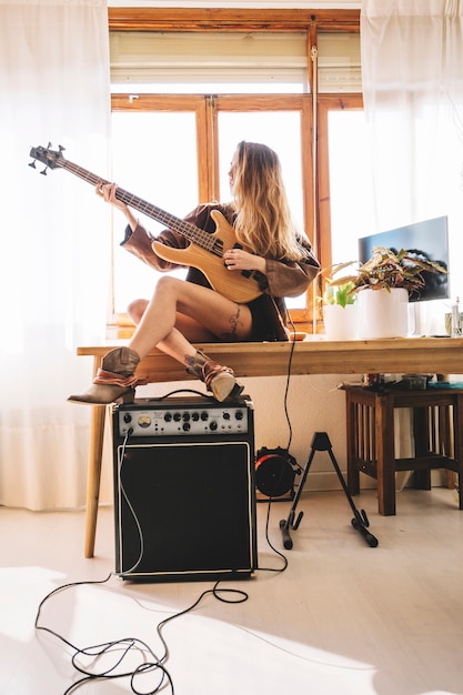 Jeune Femme Jouant De La Guitare Sur La Table Photo Gratuite