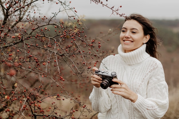Jeune femme souriante avec caméra Photo gratuit