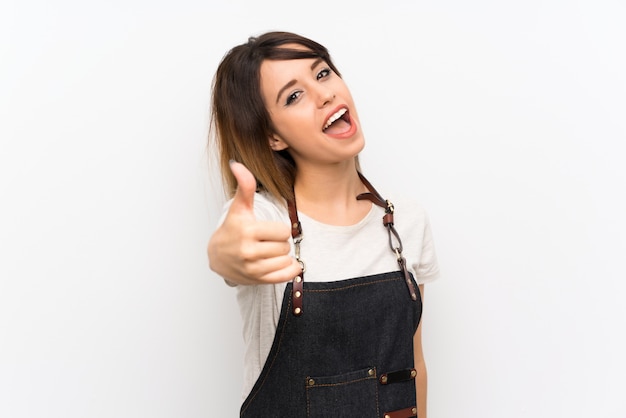 Jeune femme avec un tablier avec le pouce levé parce qu'il s'est passé quelque chose de bien Photo Premium