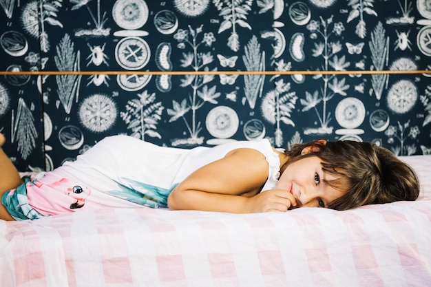 Jeune Fille Souriante Allongée Sur Le Lit Photo Gratuite 