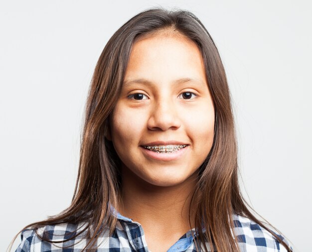 Jeune fille souriante avec des appareils sur ses dents Photo gratuit