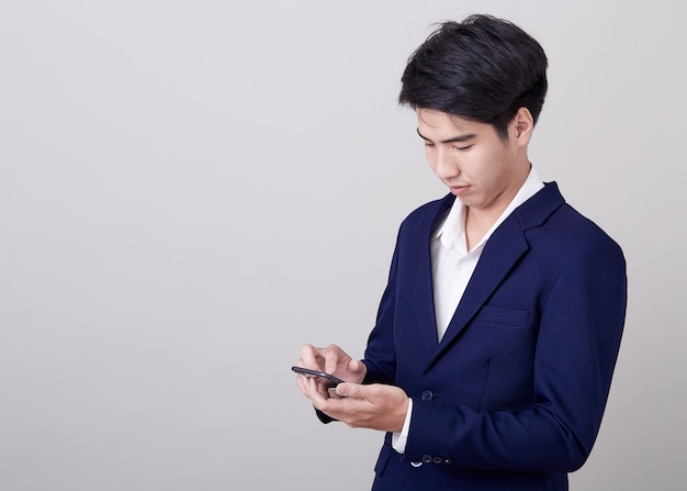 Jeune homme d'affaires asiatique à l'aide d'un smartphone Photo Premium
