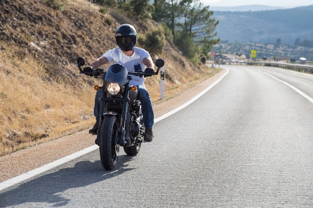 Jeune Homme Conduisant Une Moto  Sur La Route  En  Montagne 