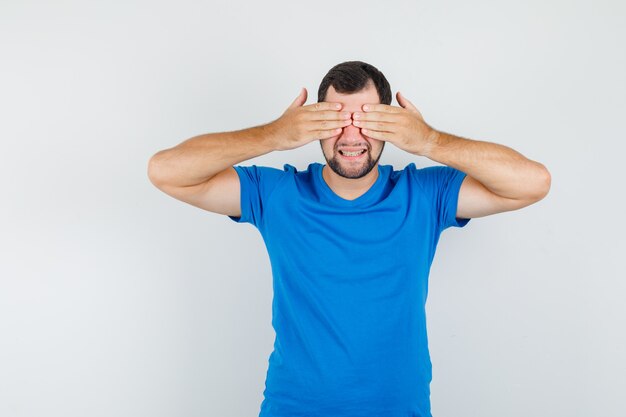 Jeune Homme Couvrant Les Yeux Avec Les Mains En T Shirt Bleu Et à La Joyeuse Photo Gratuite 