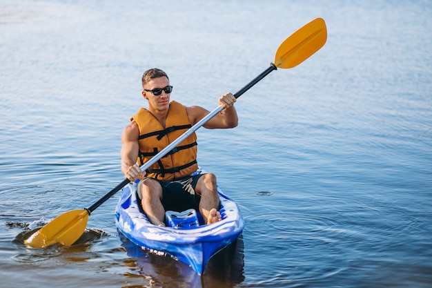 Jeune homme faisant du kayak sur la rivière Photo gratuit