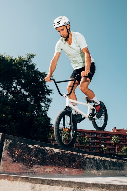 Jeune homme sautant à vélo Photo gratuit