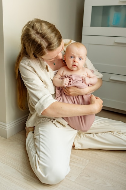 Jeune Mere Blonde En Vetements Legers Tient Dans Ses Bras Une Fille Nouveau Nee Photo Premium