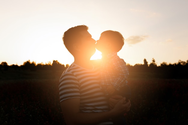 Jeune P Re Embrasse Son Fils Enfant En Bas Ge Sur Le Champ De Fleurs De Printemps Au Coucher Du