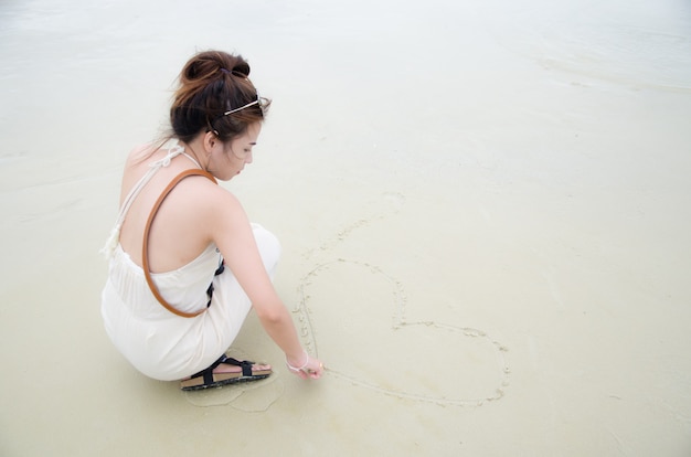 Jeunes Femmes Asiatiques Assis Sur La Plage Et Dessin Image