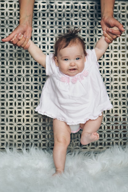 Joli Bebe Apprend A Marcher Et A Faire Ses Premiers Pas Maman Lui Tient La Main Les Pieds De L Enfant Se Bouchent Copient L Espace Photo Premium