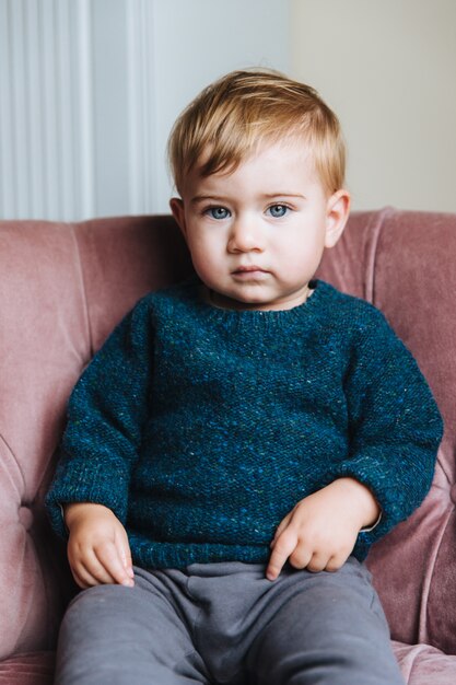 Joli Petit Enfant Aux Cheveux Clairs Et Aux Yeux Bleus Porte Un Pull Et Un Pantalon Photo Premium