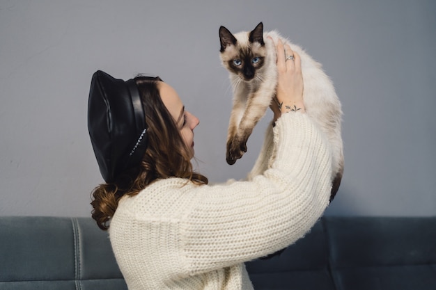 Jolie Femme Jouant Avec Un Chat Siamois Photo Gratuite