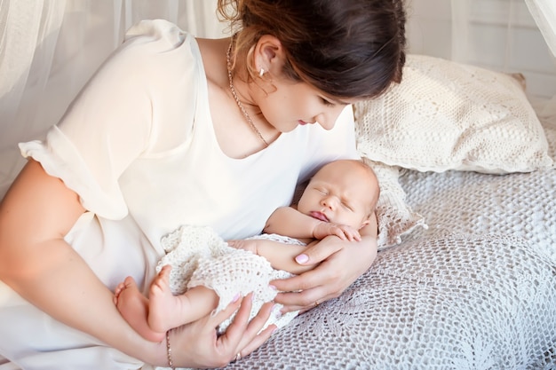 Jolie Femme Tenant Un Nouveau Ne Dans Ses Bras Heureuse Mere Et Son Bebe Nouveau Ne Glissant Dans Le Lit Photo Premium