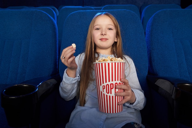 Jolie Fille Mange Du Pop Corn Regarde Un Film Au Cinema Photo Gratuite