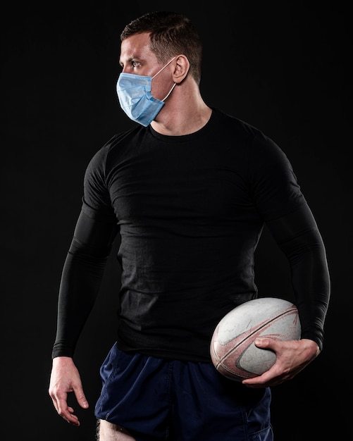 Joueur De Rugby Masculin Avec Masque Medical Et Ballon Photo Gratuite