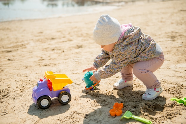 Journée familiale au parc. heureux jeune couple avec bébé nouveau-né. mère porter bébé dans un porte-bébé ergonomique Photo Premium