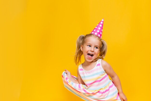 Joyeux Anniversaire Enfant Fille Avec Deux Contes De Poney En Bonnet Rose Sur Fond Jaune De Couleur Shoing Sa Langue Photo Premium