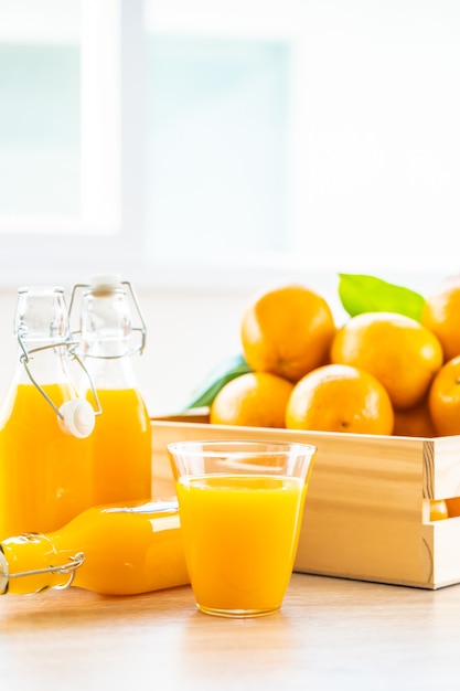 Jus d'orange frais à boire dans un verre à bouteille Photo gratuit