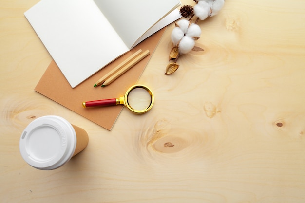 Lieu de travail moderne de couleur beige sur une table en bois avec beaucoup de choses dessus. vue de dessus Photo Premium
