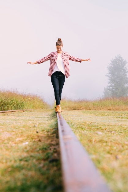 Low angle jeune fille en équilibre sur le chemin de fer Photo gratuit