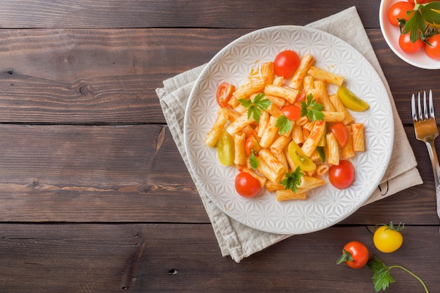Macaroni, pâtes à la sauce tomate et fromage dans une assiette sur une table en bois Photo Premium