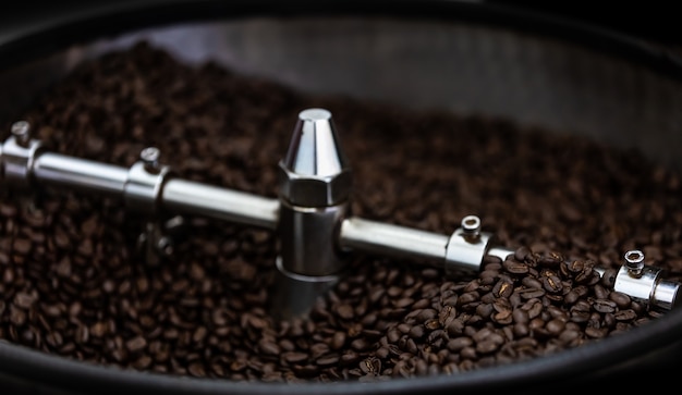 Les machines professionnelles de la filature rôtie et le mouvement des grains de café brun frais se rapprochent de la mise au point sélective Photo Premium