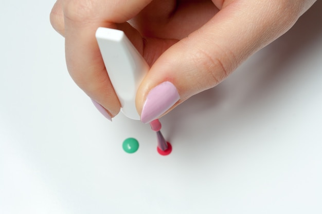 Main de femme avec un pinceau de vernis à ongles Photo Premium