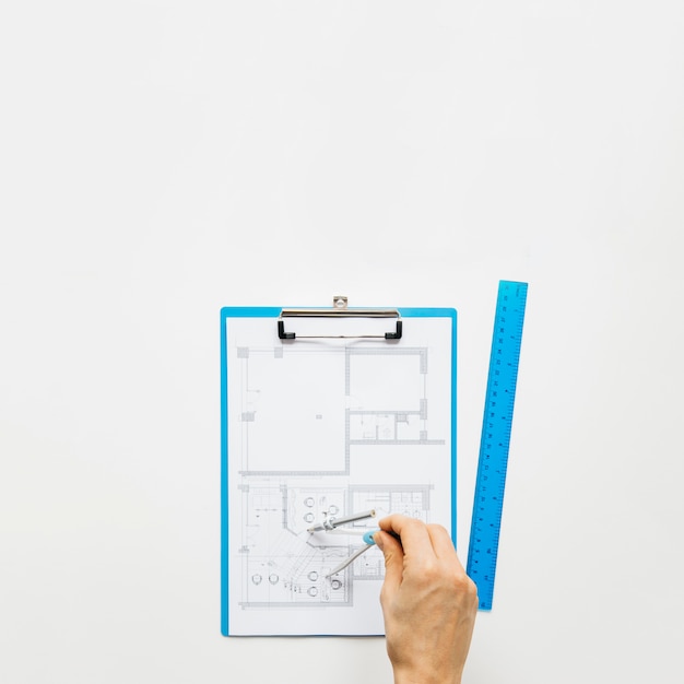 Main humaine faisant blueprint using rounder on white desk Photo gratuit