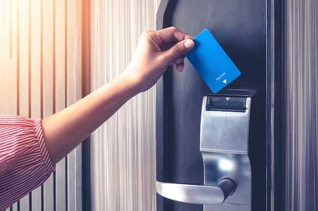 La main insérant la carte clé pour déverrouiller une authentification de sécurité de la porte dans la sauvegarde de l'hôtel ou de l'appartement Photo Premium