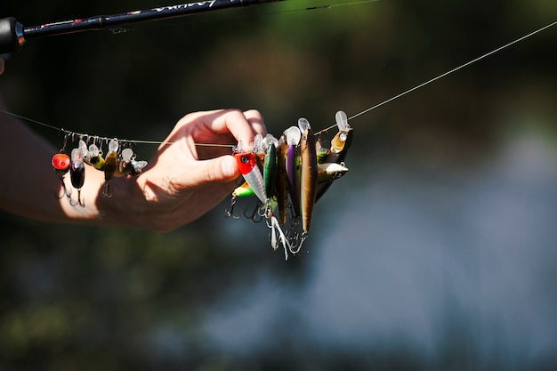 Main de pêcheur choisissant un appât sur une ligne de pêche Photo gratuit