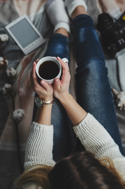 Mains féminines tenant une tasse blanche avec boisson. concept de style de vie. vue de dessus Photo Premium