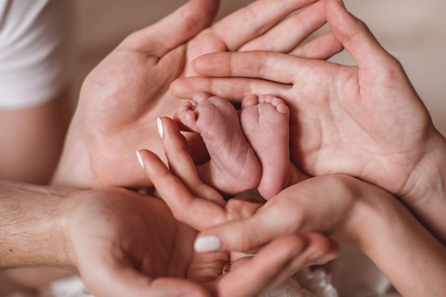 Les Mains Des Parents Tiennent Les Pieds De Bebe Photo Premium